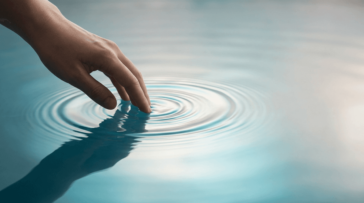 A gentle hand creating soft ripples in a still pool of water, representing pressure without pain